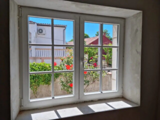 PVC prozor s prečkama ugrađen u kamenu kuću &ndash; energetski učinkovita PVC stolarija s dobrom toplinskom izolacijom i očuvanim tradicionalnim izgledom